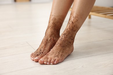 Photo of Woman with body scrub on her feet indoors, closeup