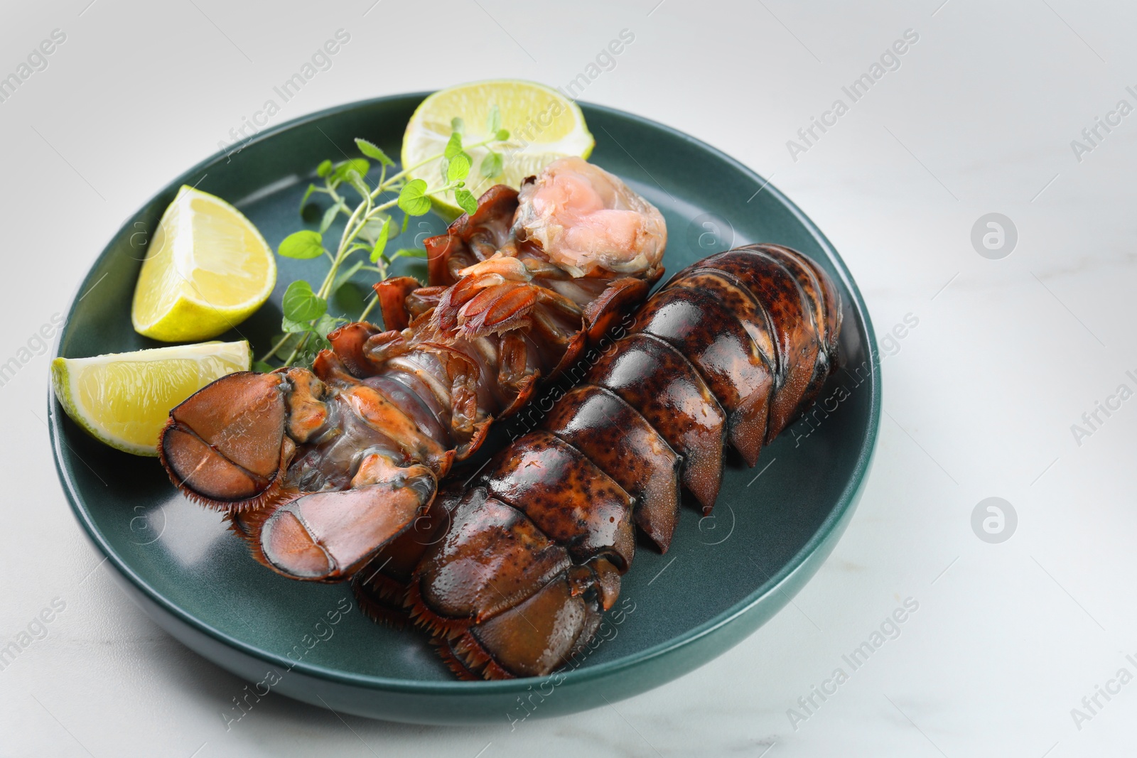 Raw lobster tails, lime and microgreens on white marble table, closeup Photo of Raw lobster tails, lime and microgreens on white marble table, closeup