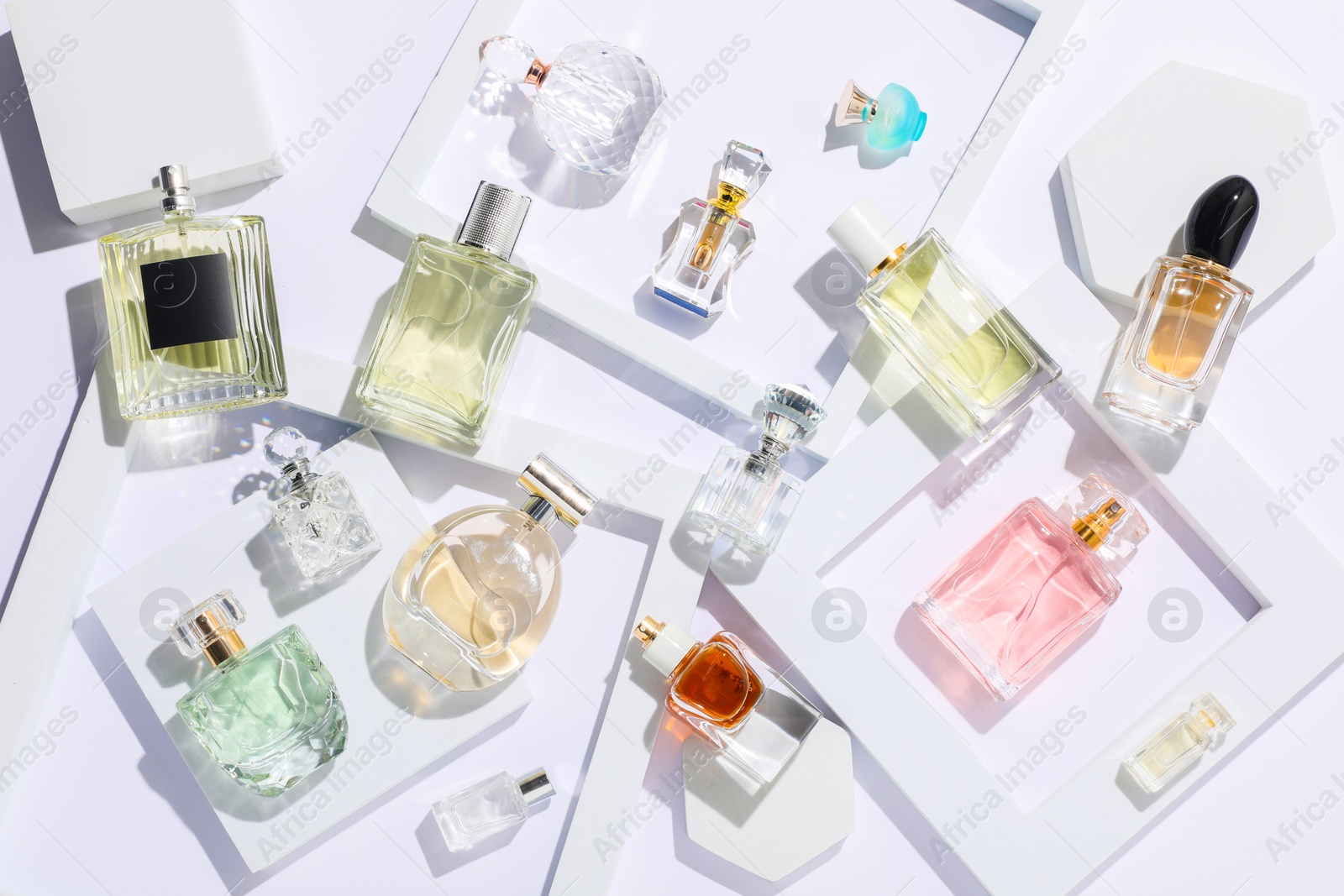 Different luxury perfumes on white background, flat lay Photo of Different luxury perfumes on white background, flat lay