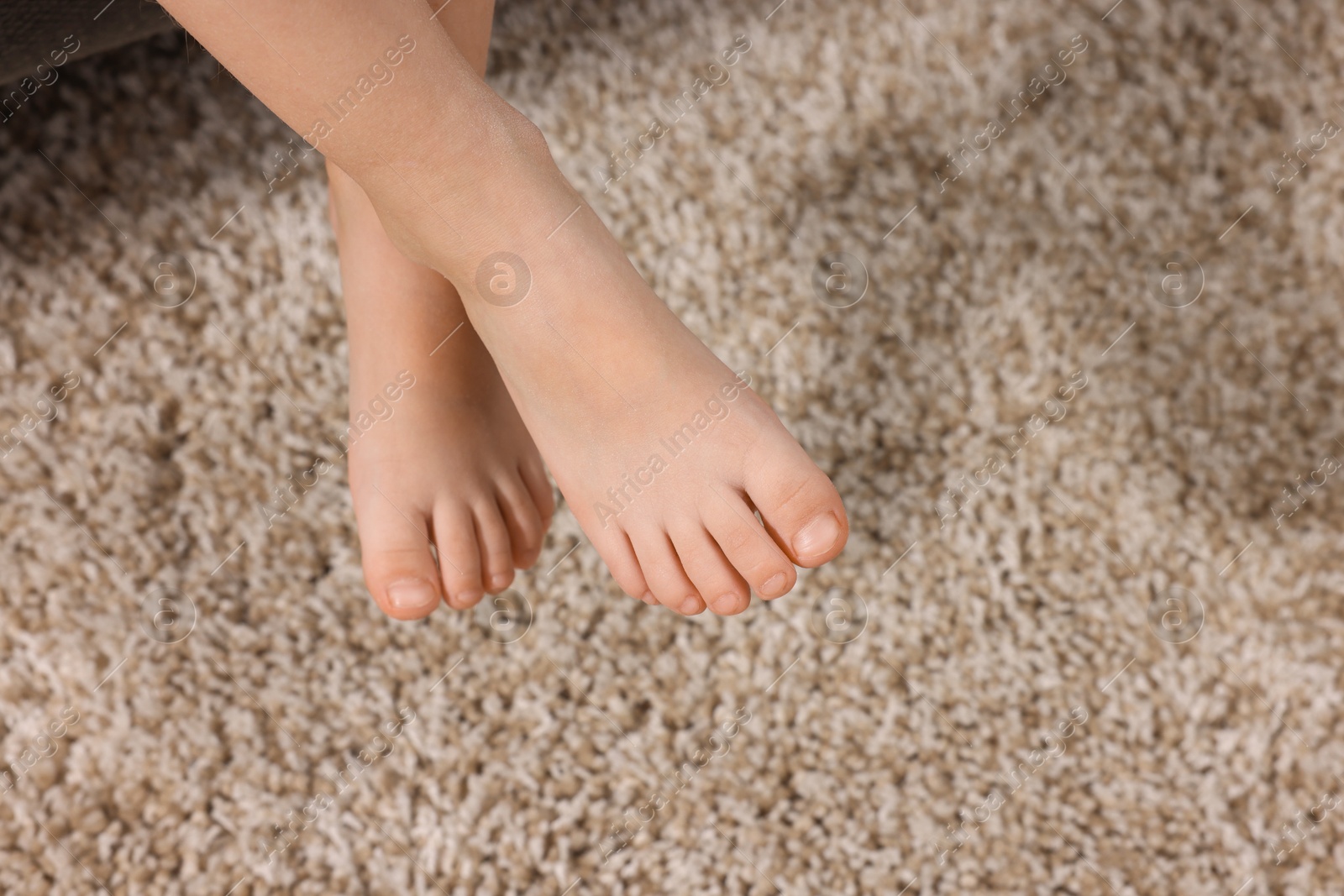 Little child above soft beige carpet indoors, closeup. Space for text Photo of Little child above soft beige carpet indoors, closeup. Space for text