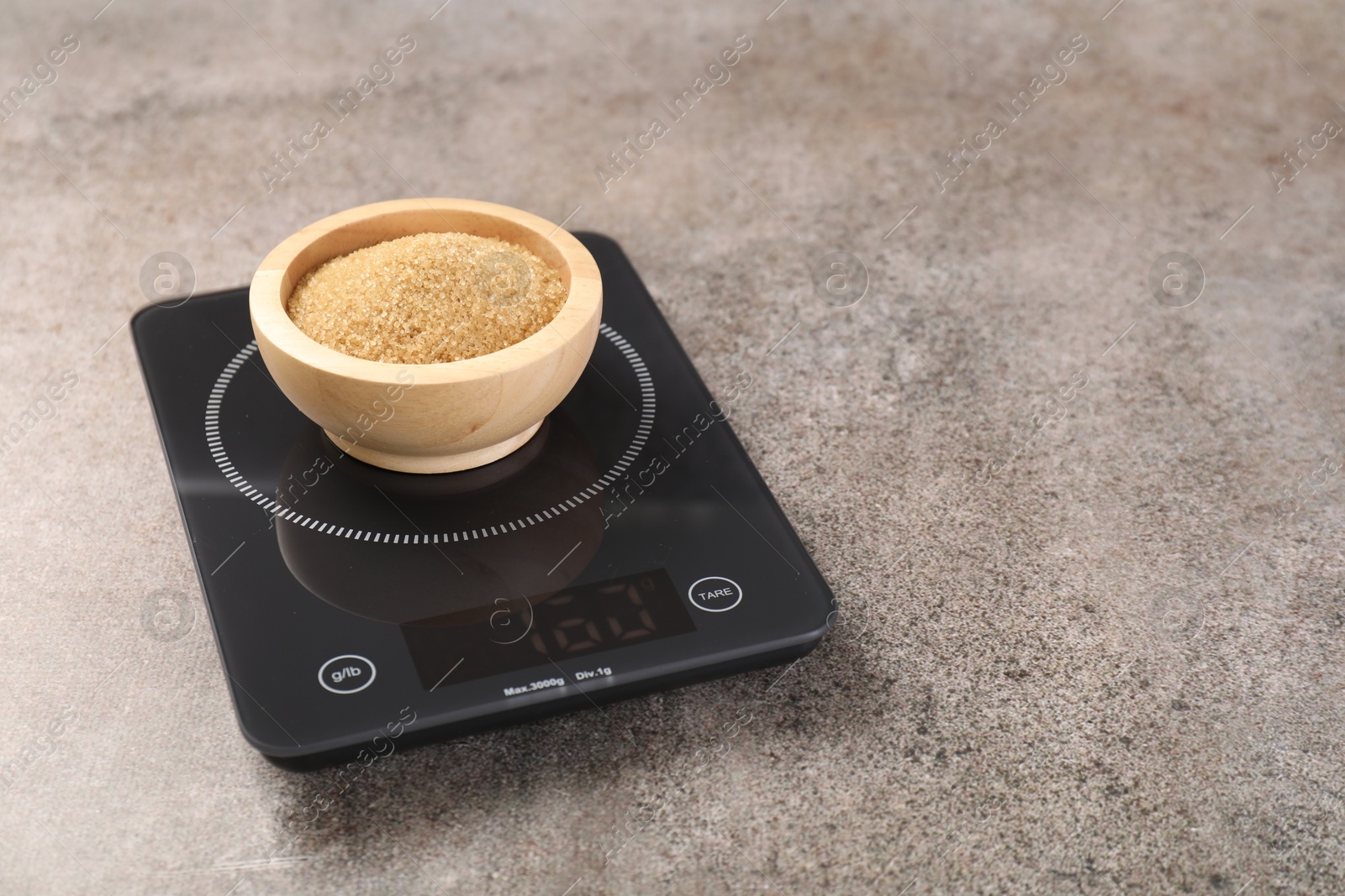 Digital kitchen scale with bowl of sugar on grey table, closeup. Space for text Photo of Digital kitchen scale with bowl of sugar on grey table, closeup. Space for text