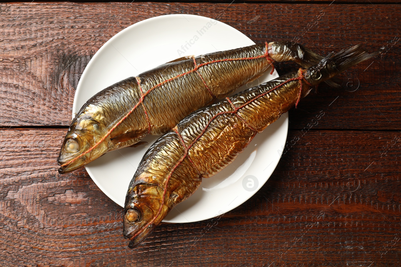 Delicious smoked herrings on wooden table, top view Photo of Delicious smoked herrings on wooden table, top view