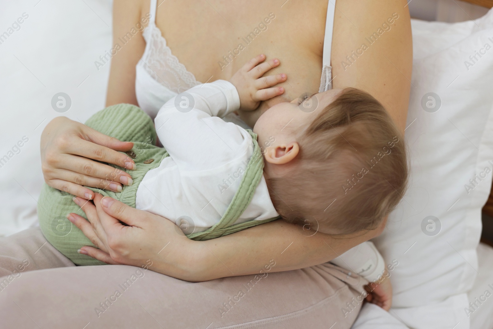 Mother breastfeeding her little baby on bed at home, closeup Photo of Mother breastfeeding her little baby on bed at home, closeup