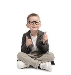 Photo of Cute little boy in glasses showing thumbs up on white background