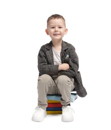 Photo of Cute little boy on books against white background