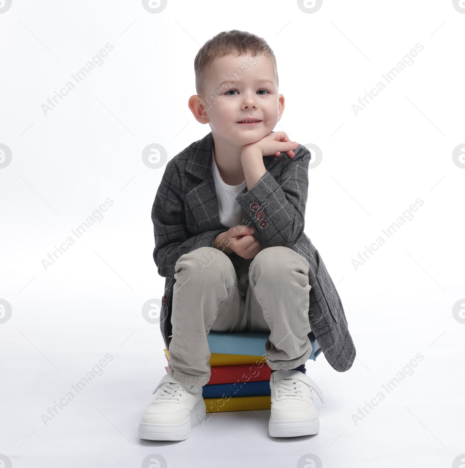 Cute little boy on books against white background Photo of Cute little boy on books against white background