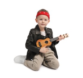 Photo of Cute little boy playing toy guitar on white background