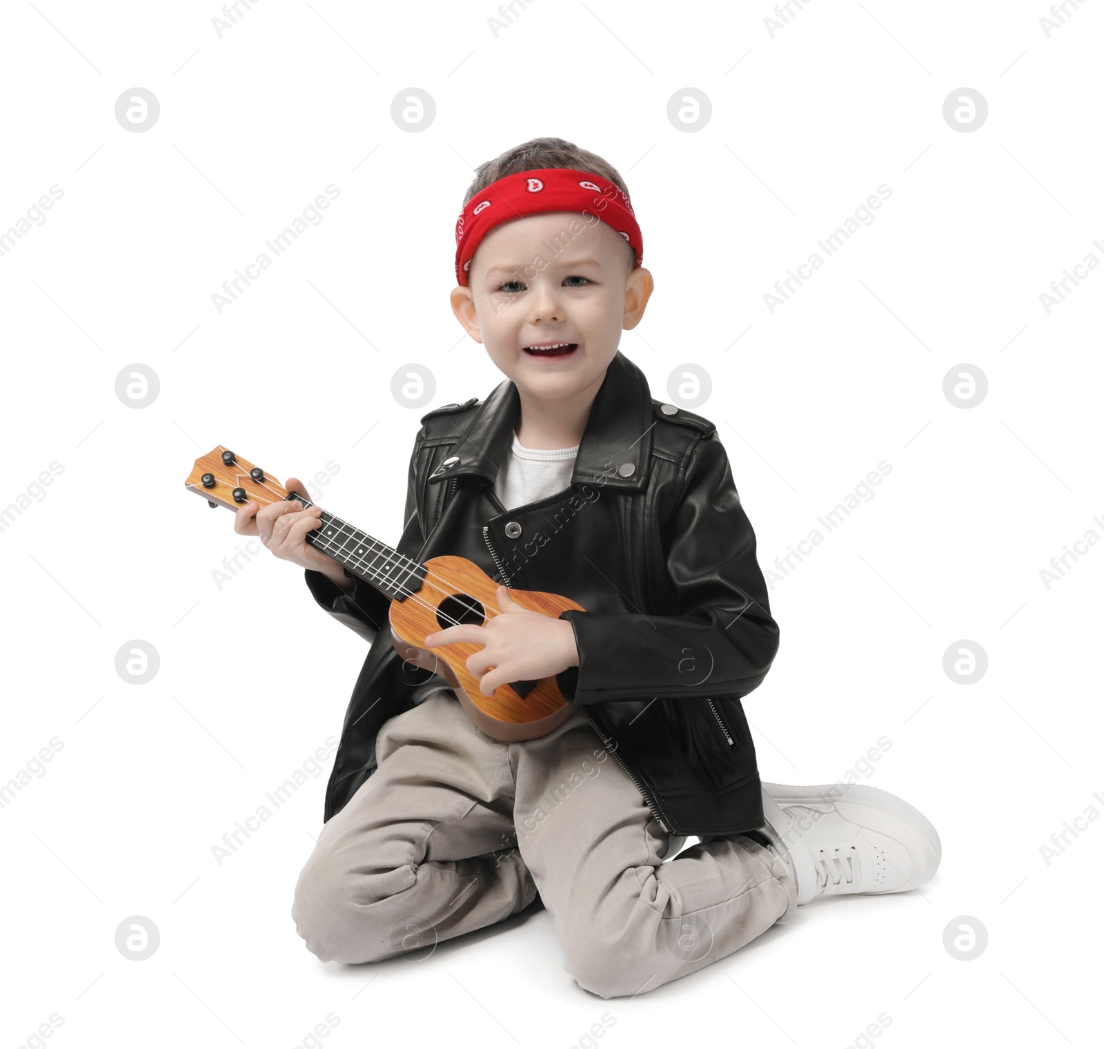 Cute little boy playing toy guitar on white background Photo of Cute little boy playing toy guitar on white background