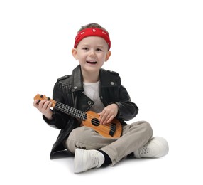 Photo of Cute little boy playing toy guitar on white background
