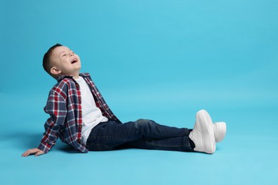Photo of Cute little boy on light blue background, space for text