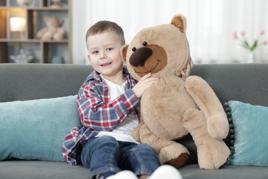 Photo of Cute little boy with toy bear at home