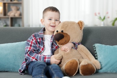 Photo of Cute little boy with toy bear at home
