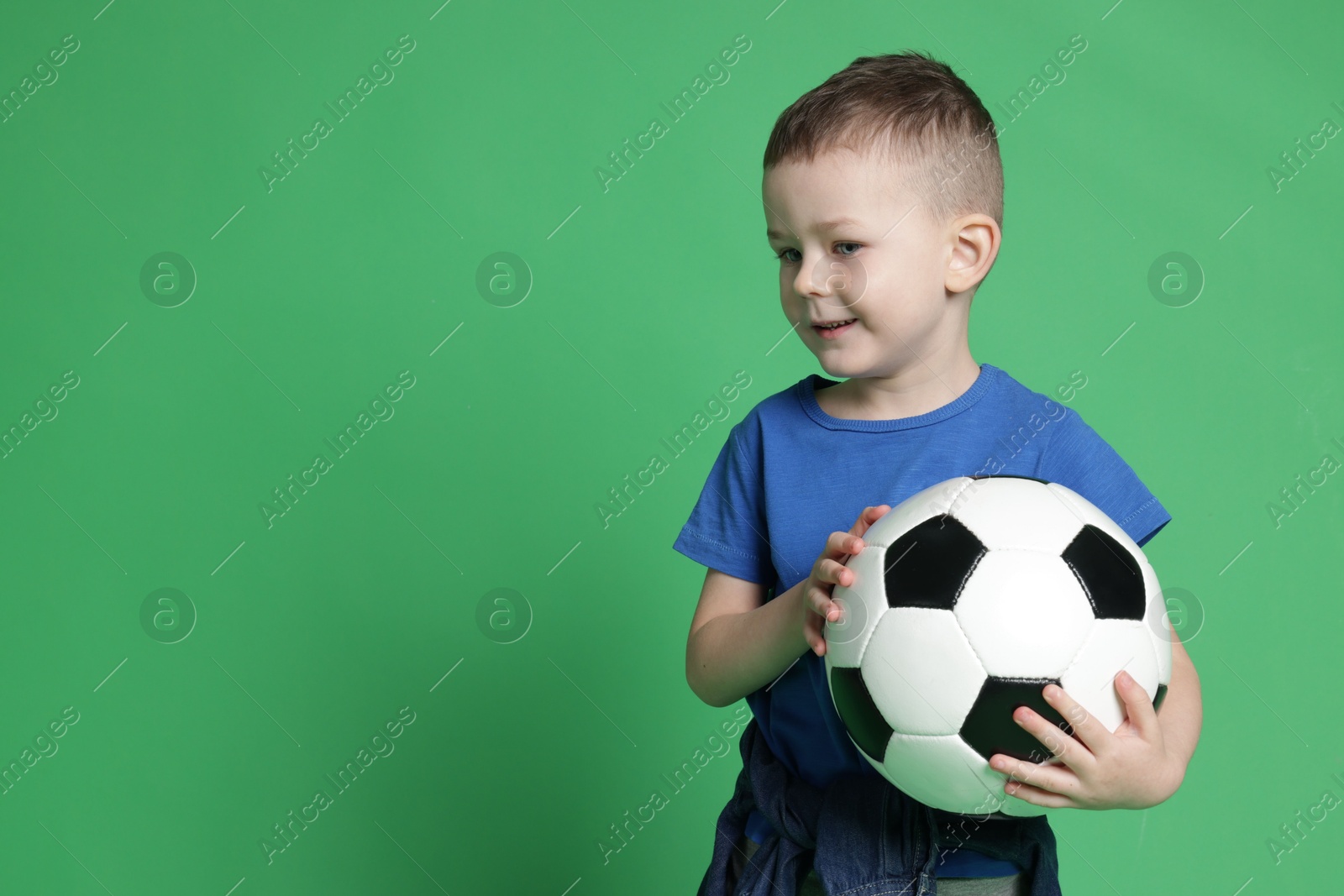 Cute little boy with soccer ball on green background, space for text Photo of Cute little boy with soccer ball on green background, space for text