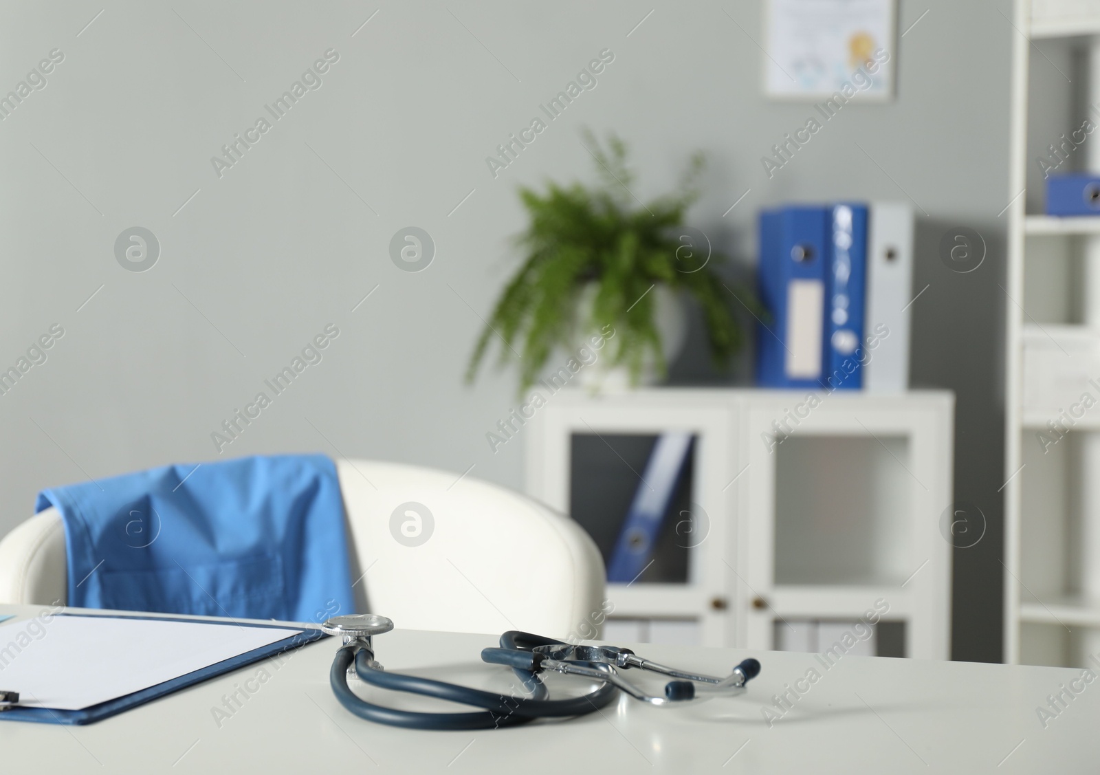 Doctor's workplace. Stethoscope and clipboard on white table in medical office Photo of Doctor's workplace. Stethoscope and clipboard on white table in medical office