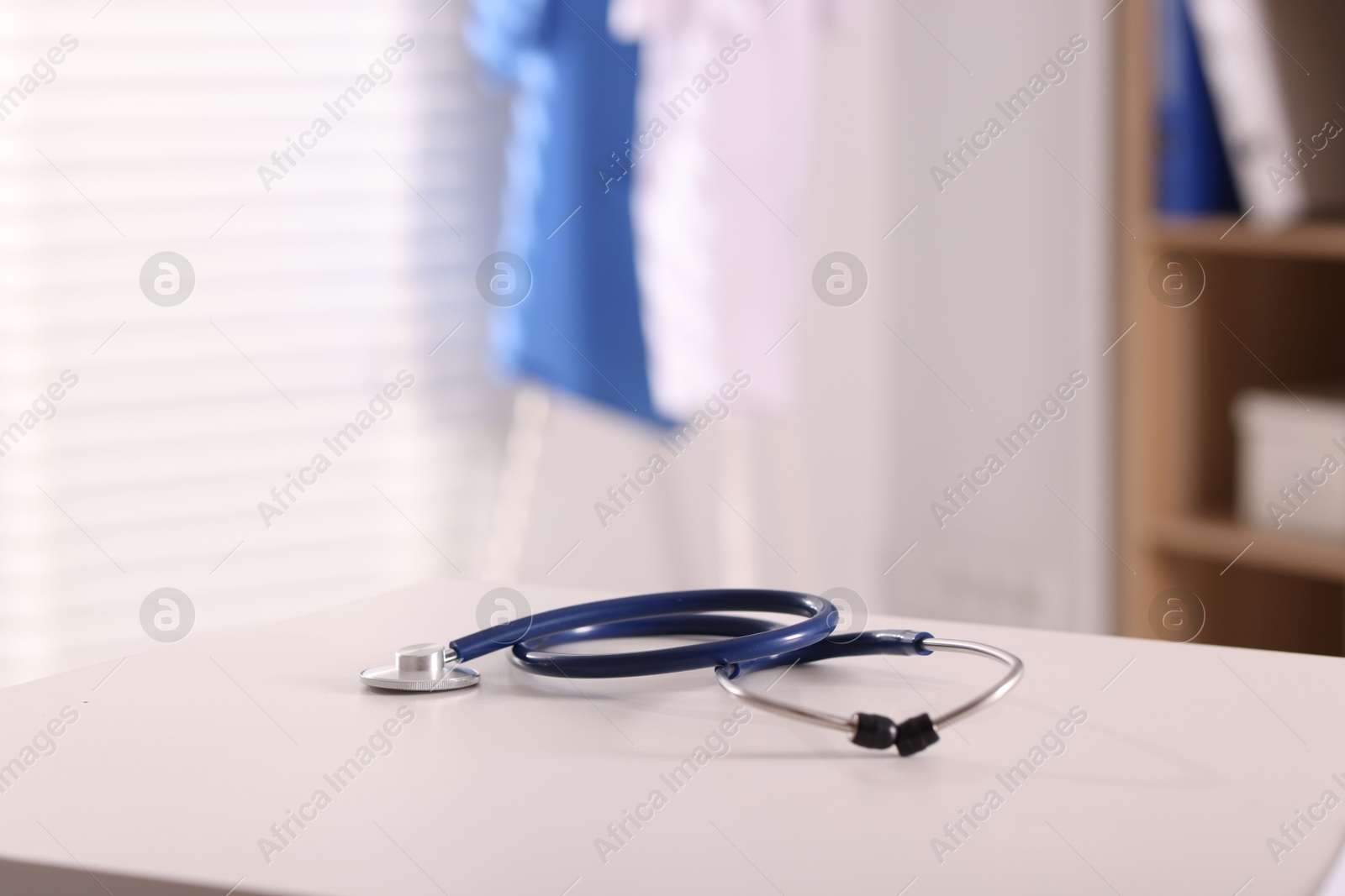 Photo of Doctor's workplace. Stethoscope on white table in medical office, space for text