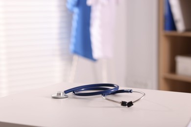 Doctor's workplace. Stethoscope on white table in medical office, space for text