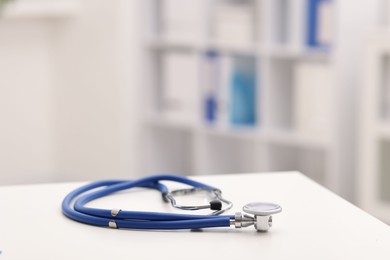 Photo of Doctor's workplace. Stethoscope on white table in medical office, closeup. Space for text