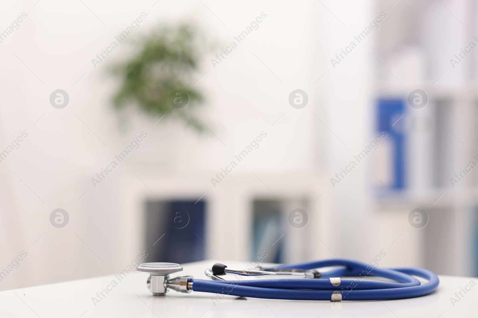Doctor's workplace. Stethoscope on white table in medical office, closeup. Space for text Photo of Doctor's workplace. Stethoscope on white table in medical office, closeup. Space for text