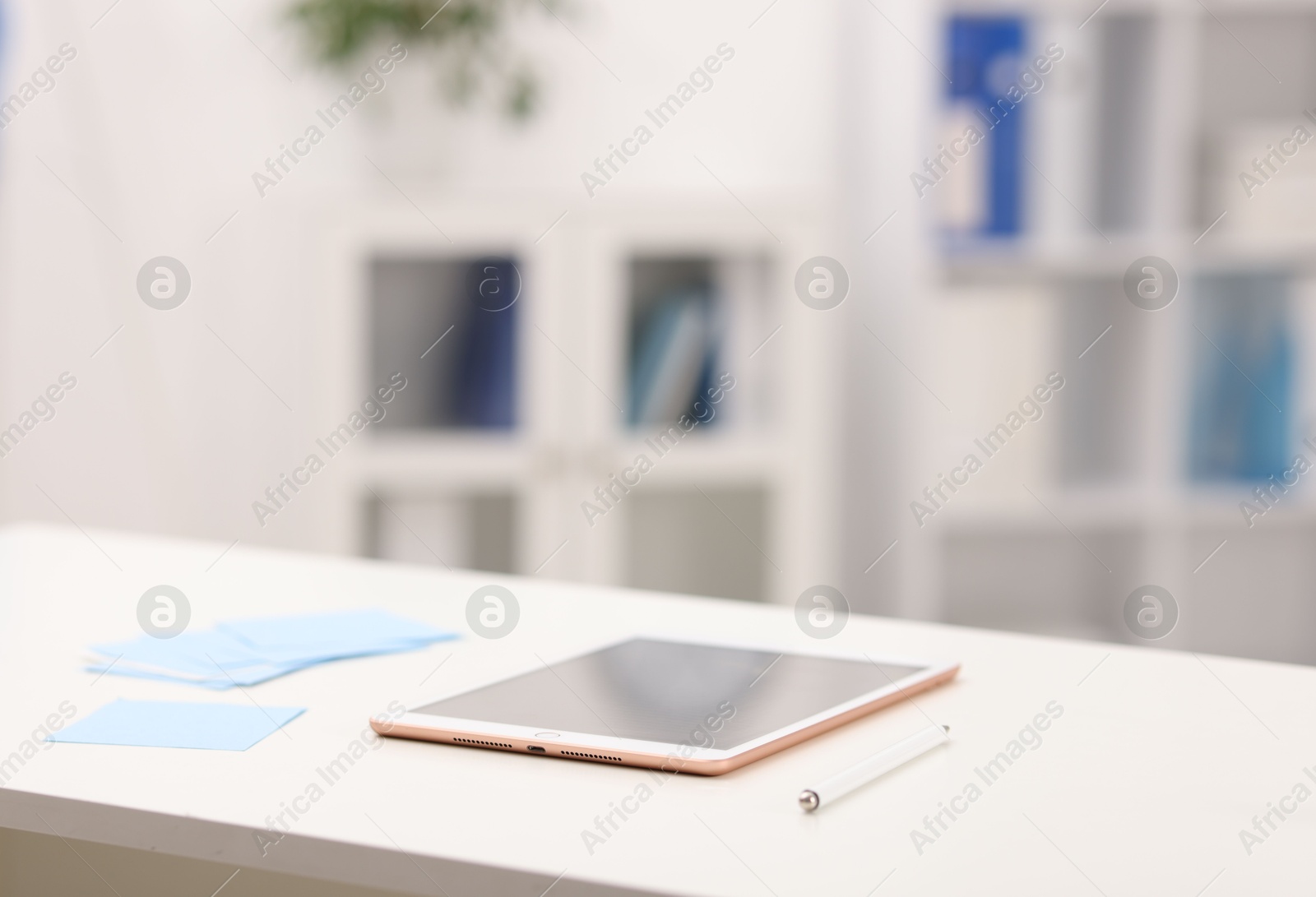 Doctor's workplace. Tablet, pen and sticky notes on white table in medical office, closeup. Space for text Photo of Doctor's workplace. Tablet, pen and sticky notes on white table in medical office, closeup. Space for text