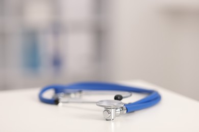 Photo of Doctor's workplace. Stethoscope on white table in medical office, closeup. Space for text