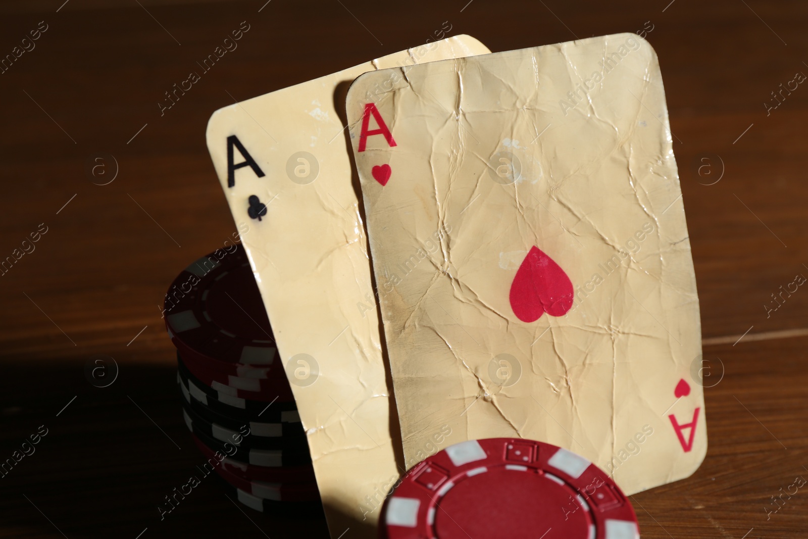 Old vintage playing cards and poker chips on wooden table, closeup Photo of Old vintage playing cards and poker chips on wooden table, closeup