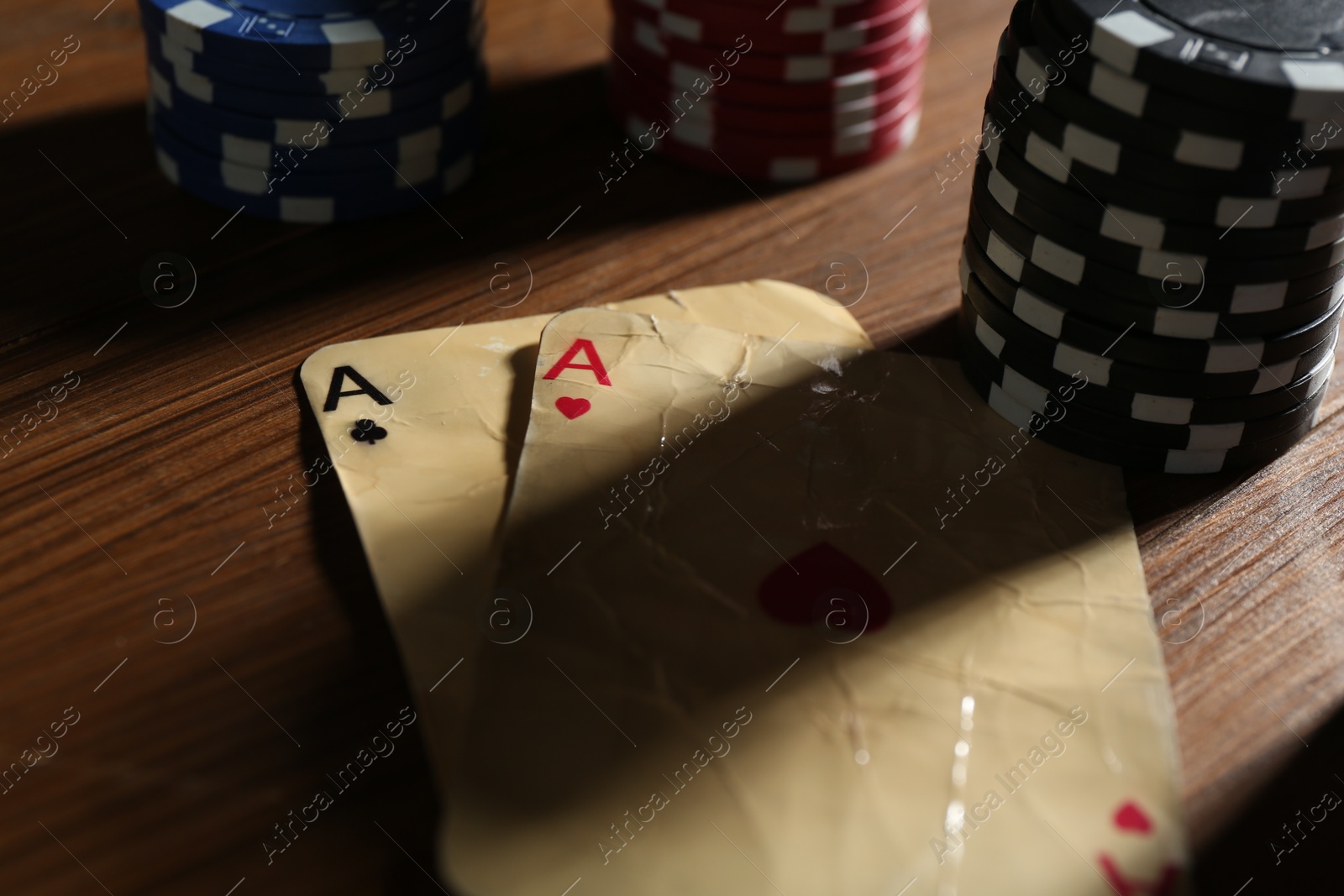 Old vintage playing cards and poker chips on wooden table, closeup Photo of Old vintage playing cards and poker chips on wooden table, closeup