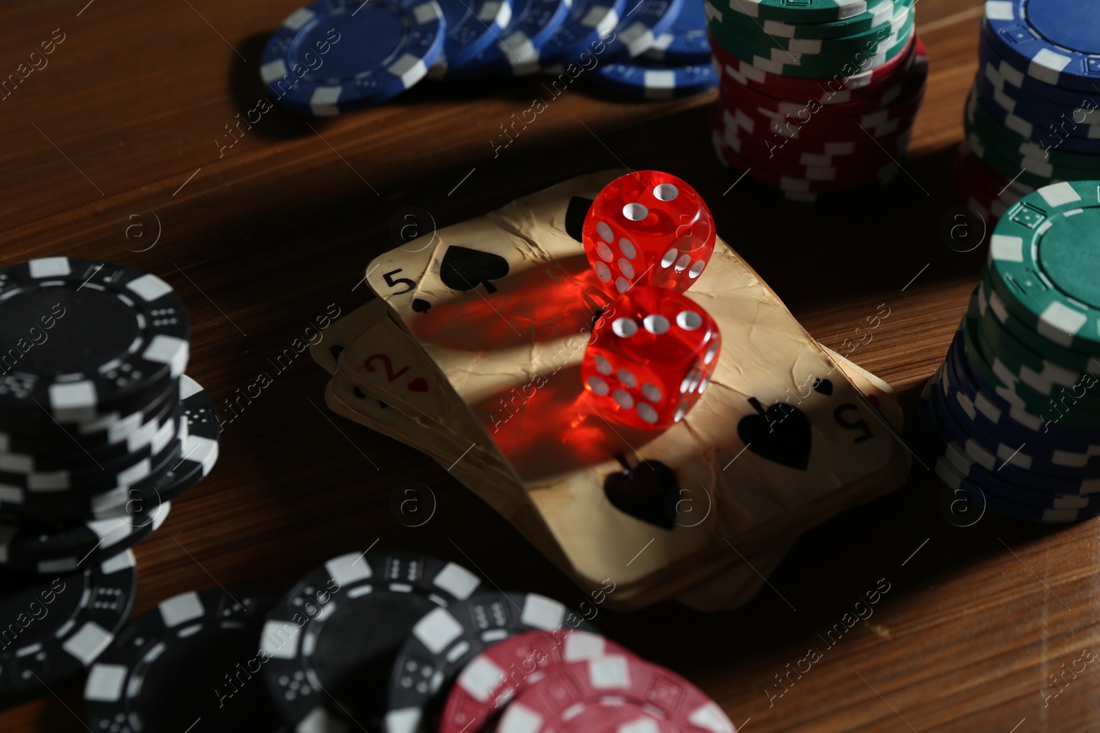 Old vintage playing cards, poker chips and dices on wooden table, closeup Photo of Old vintage playing cards, poker chips and dices on wooden table, closeup