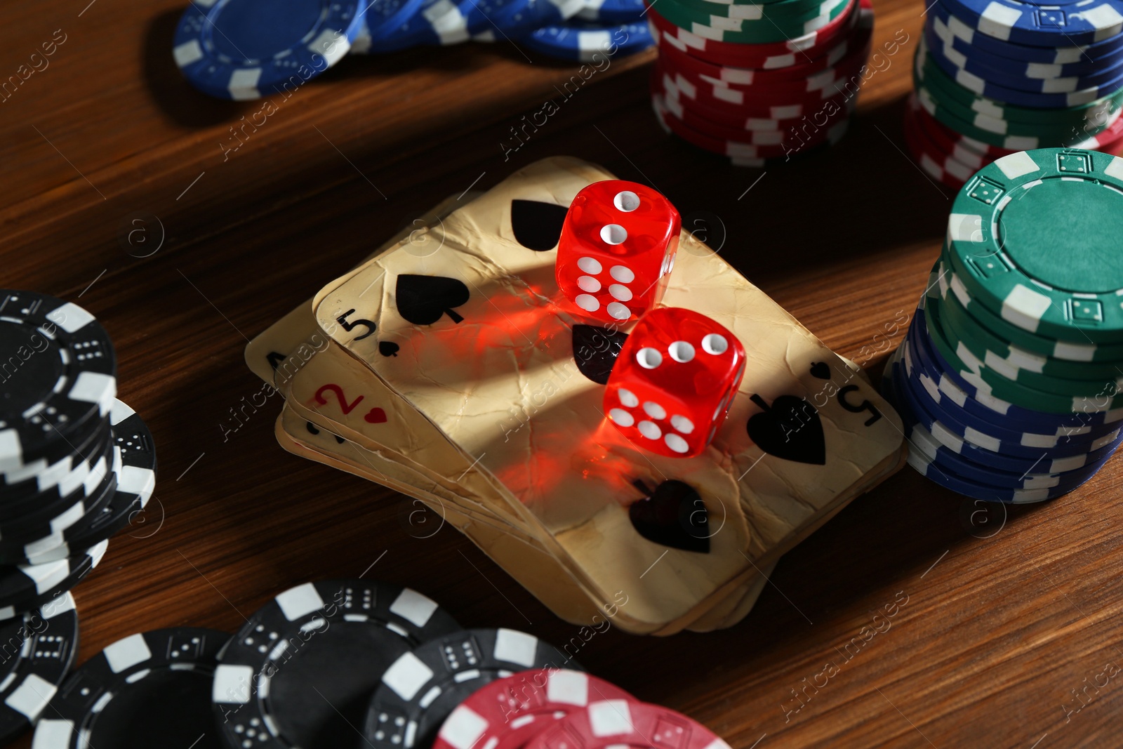 Old vintage playing cards, poker chips and dices on wooden table, closeup Photo of Old vintage playing cards, poker chips and dices on wooden table, closeup