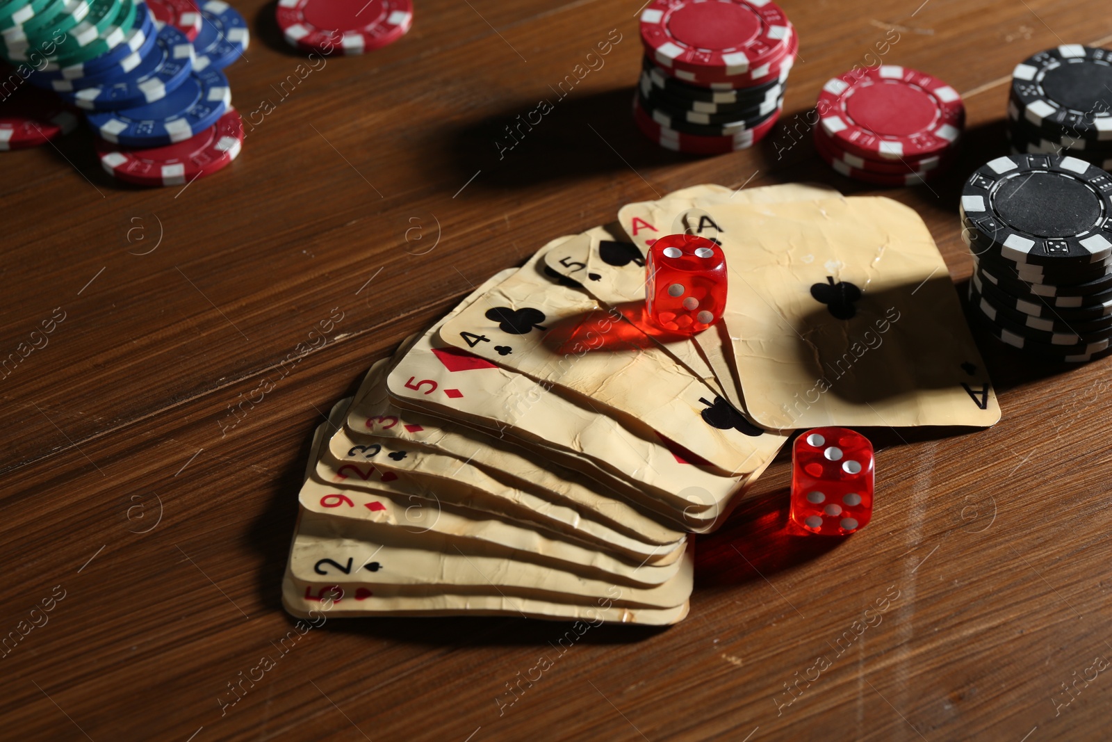 Old vintage playing cards, poker chips and dices on wooden table, closeup Photo of Old vintage playing cards, poker chips and dices on wooden table, closeup