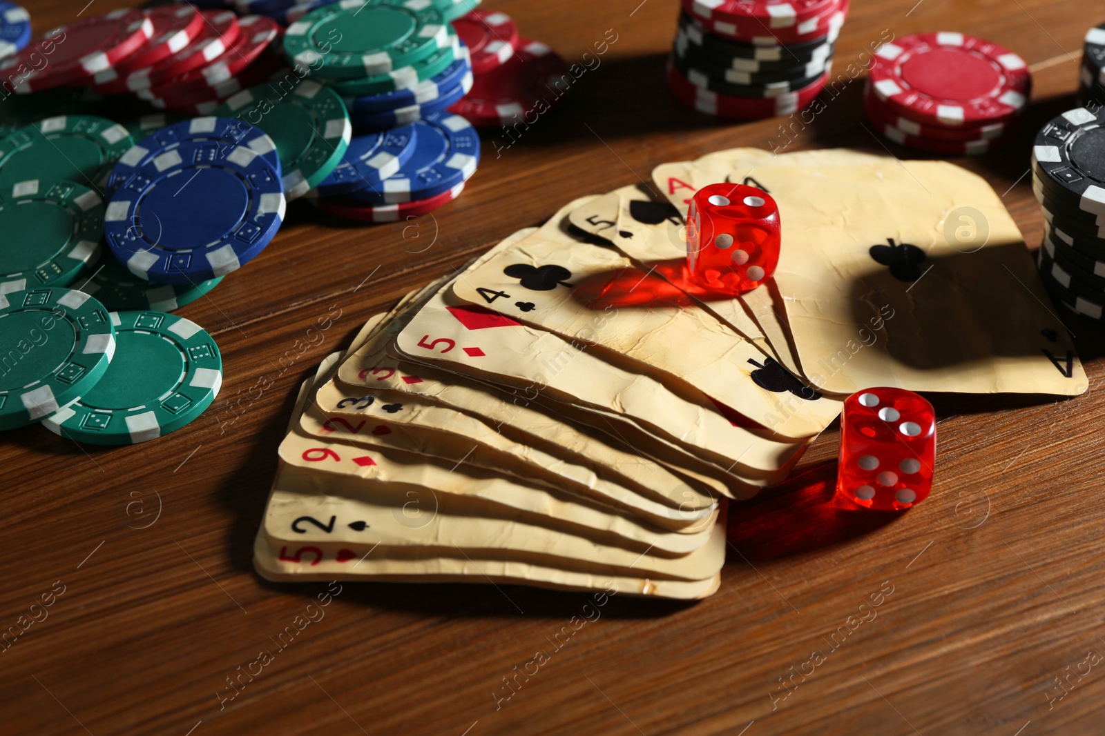 Old vintage playing cards, poker chips and dices on wooden table, closeup Photo of Old vintage playing cards, poker chips and dices on wooden table, closeup