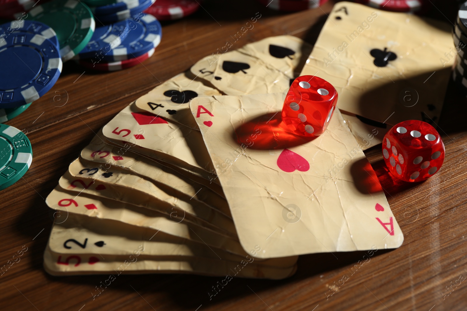 Old vintage playing cards, poker chips and dices on wooden table, closeup Photo of Old vintage playing cards, poker chips and dices on wooden table, closeup