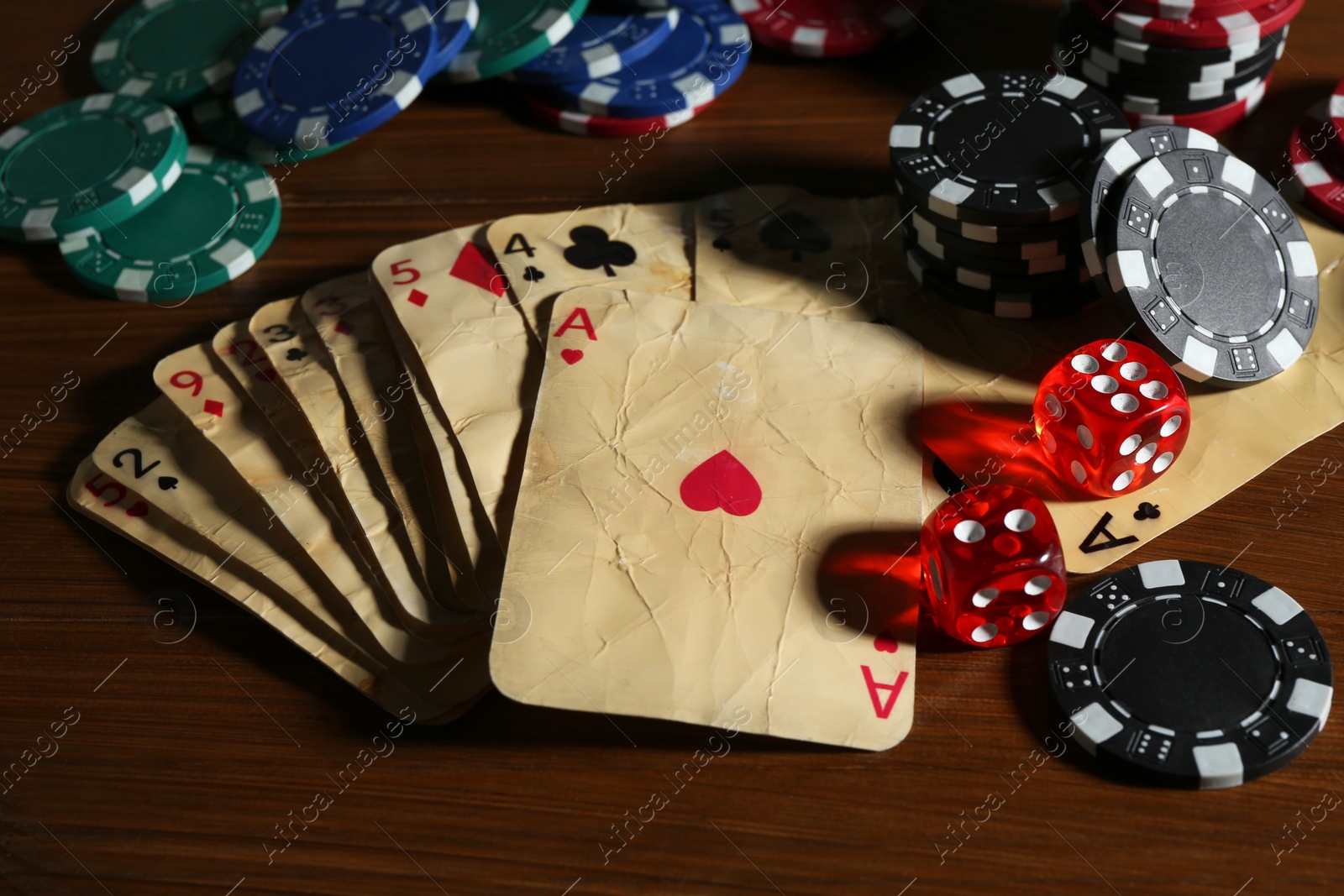 Old vintage playing cards, poker chips and dices on wooden table, closeup Photo of Old vintage playing cards, poker chips and dices on wooden table, closeup