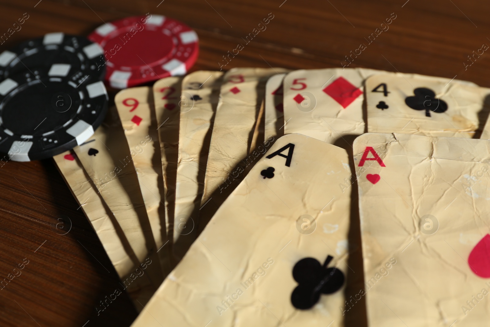 Old vintage playing card and poker chips on wooden table, closeup Photo of Old vintage playing card and poker chips on wooden table, closeup