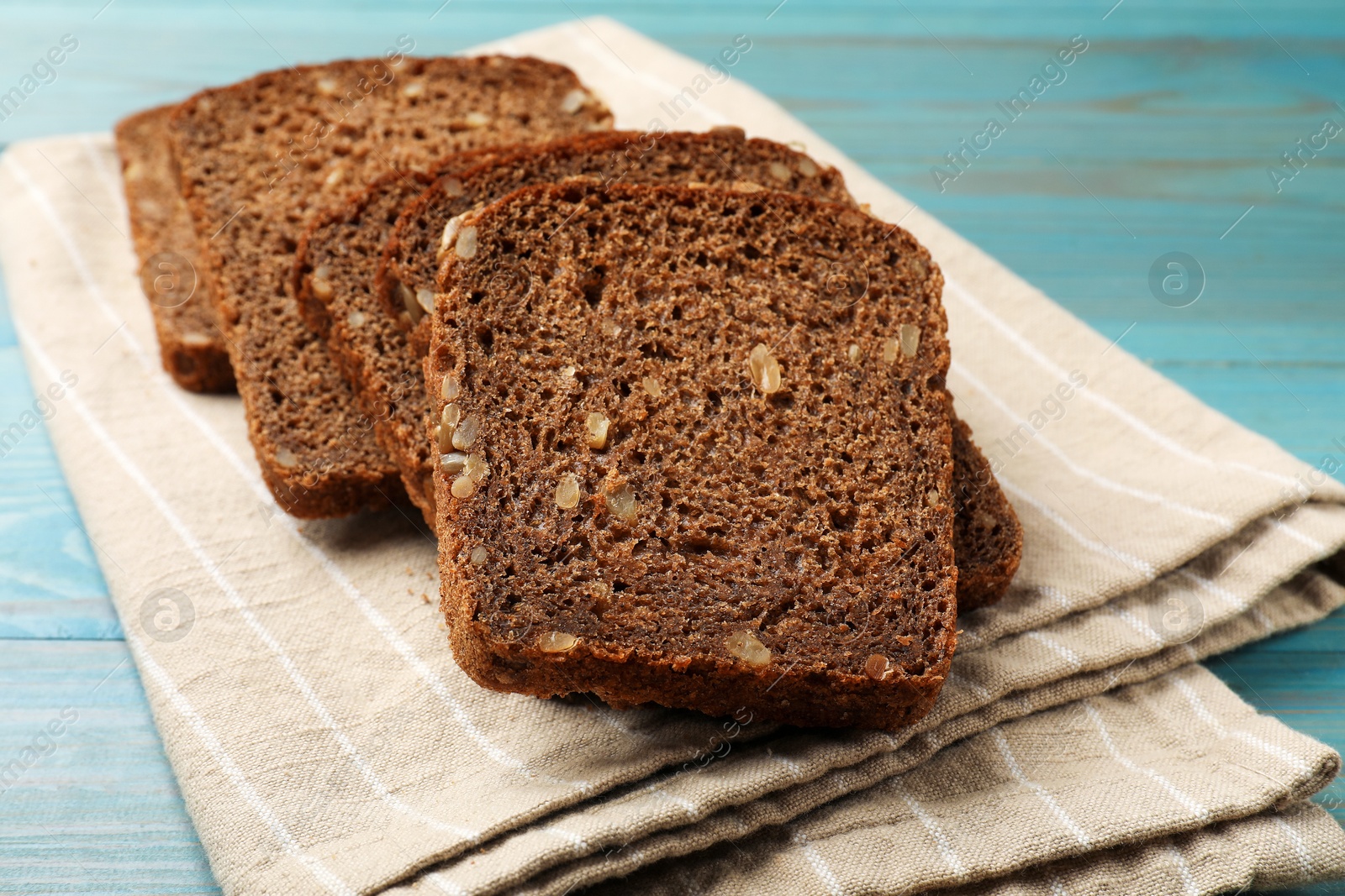 Pieces of fresh bread on light blue wooden table, closeup Photo of Pieces of fresh bread on light blue wooden table, closeup