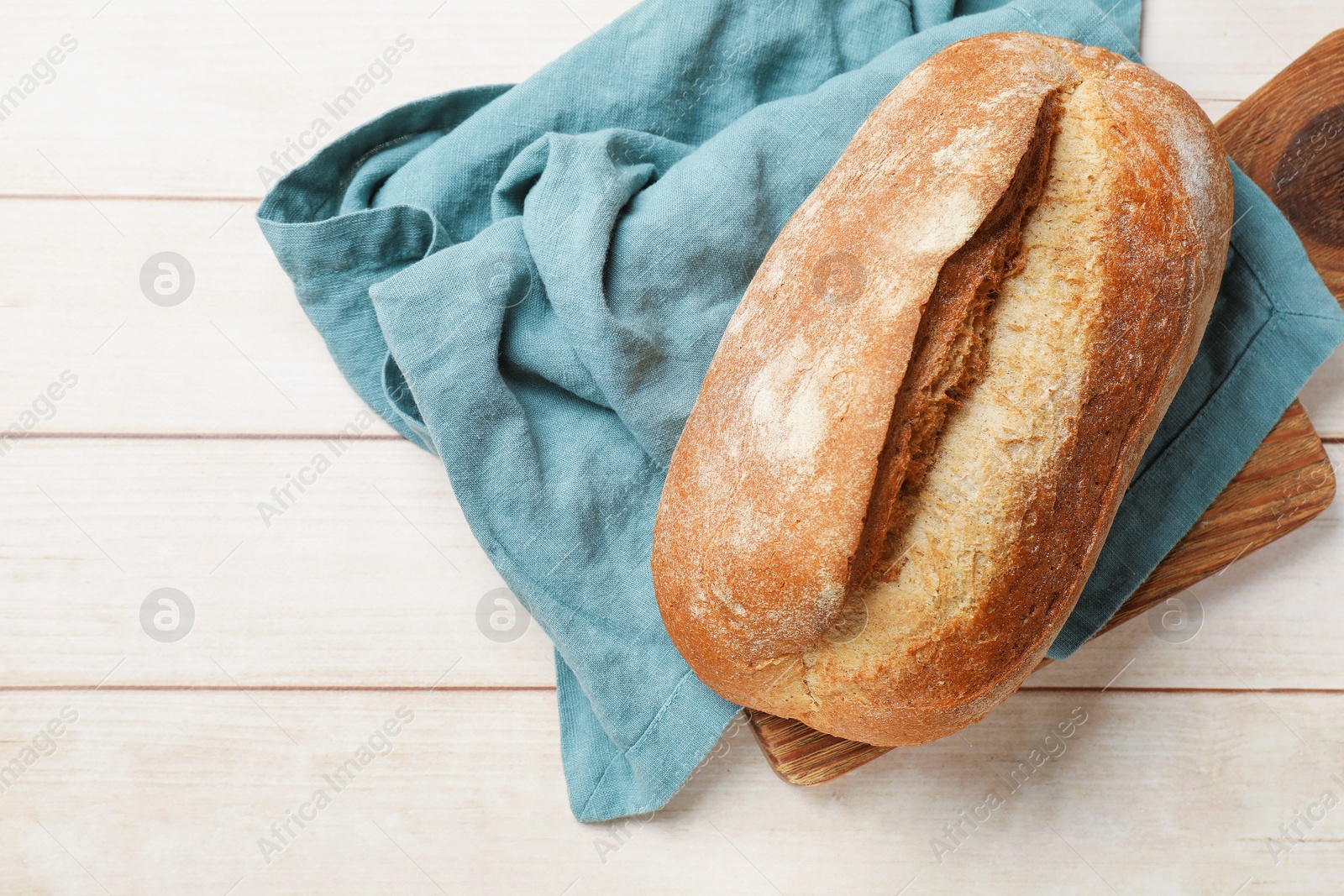Fresh loaf of bread on wooden table, top view. Space for text Photo of Fresh loaf of bread on wooden table, top view. Space for text