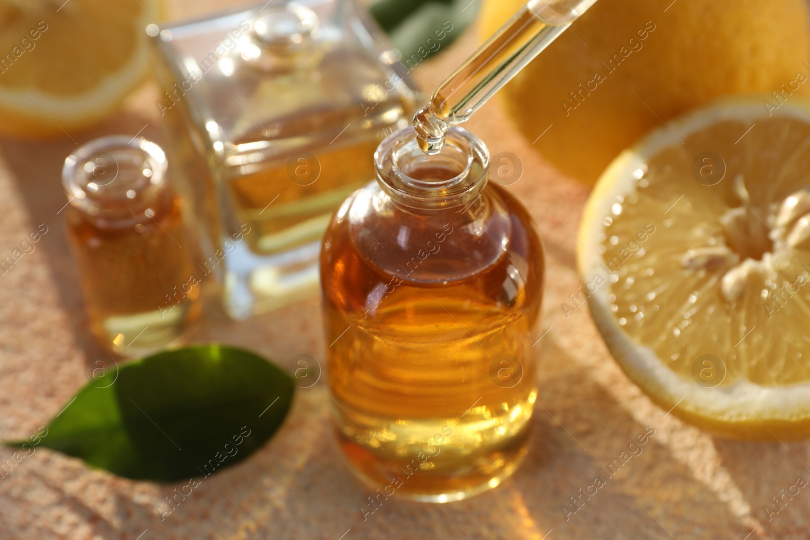 Taking aromatic oil from perfume bottle with dropper on beige textured background, closeup Photo of Taking aromatic oil from perfume bottle with dropper on beige textured background, closeup