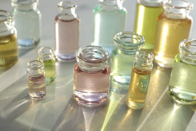 Photo of Perfume bottles with aromatic oils on light background, closeup