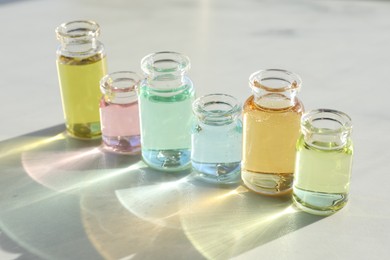 Photo of Perfume bottles with aromatic oils on light background, closeup