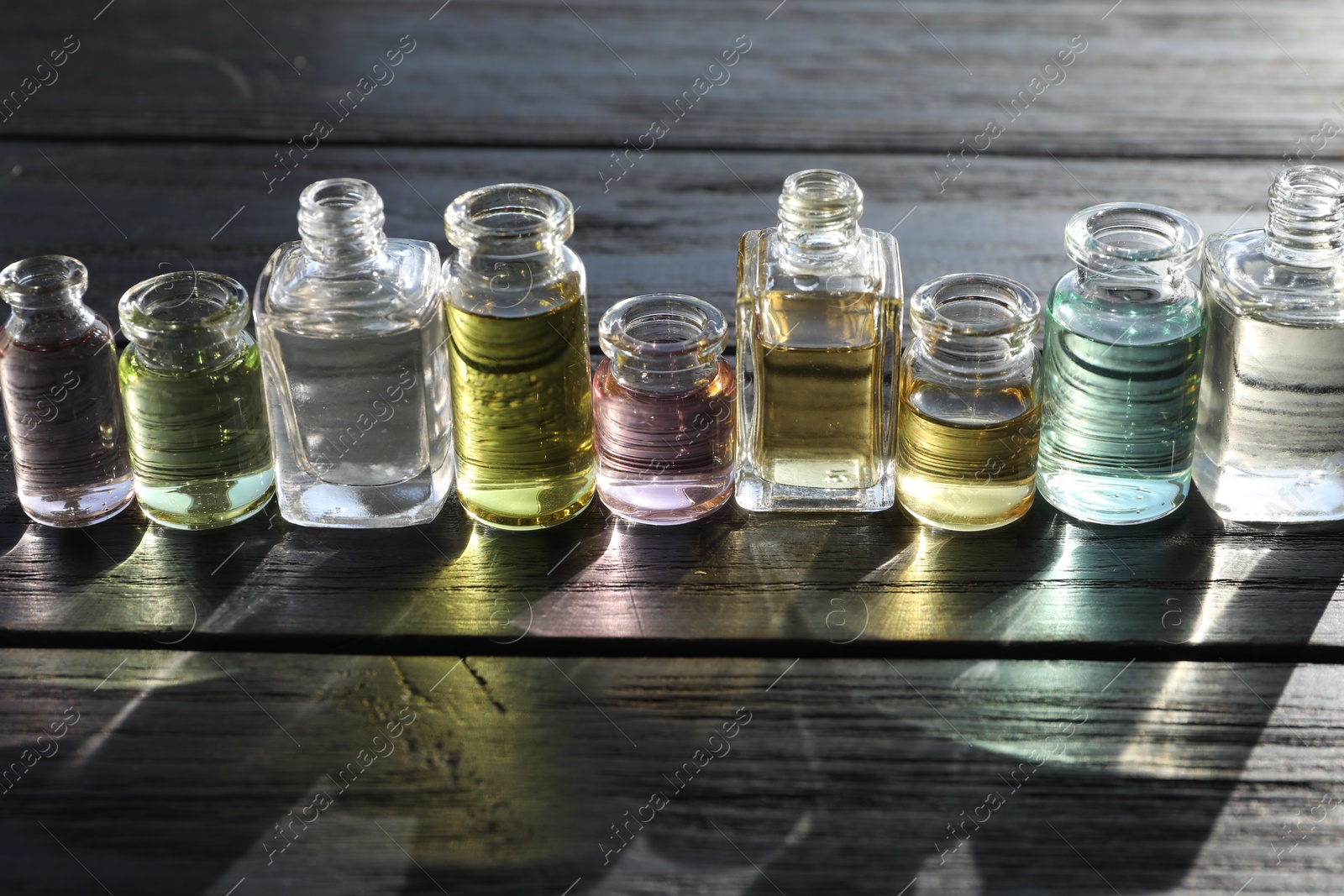 Perfume bottles with aromatic oils on black wooden background, closeup Photo of Perfume bottles with aromatic oils on black wooden background, closeup