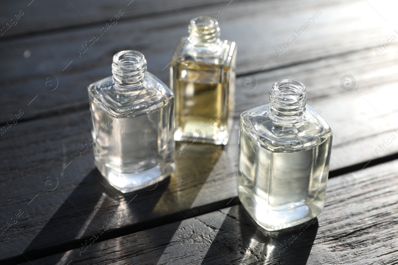 Perfume bottles with aromatic oils on black wooden background, closeup Photo of Perfume bottles with aromatic oils on black wooden background, closeup