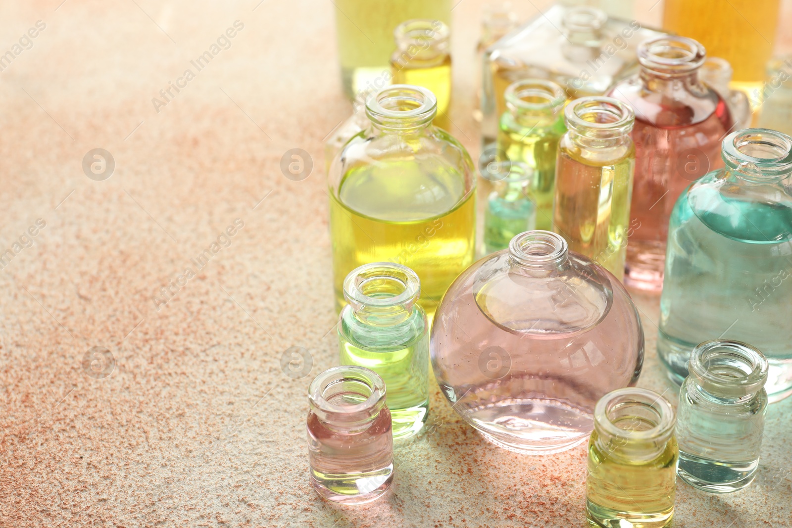 Perfume bottles with aromatic oils on beige textured background, closeup. Space for text Photo of Perfume bottles with aromatic oils on beige textured background, closeup. Space for text