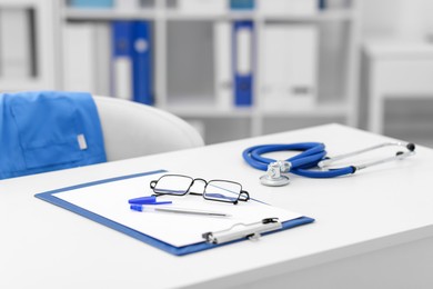 Photo of Doctor's workplace with stethoscope and paperwork on desk, closeup. Space for text