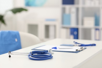 Photo of Stethoscope and paperwork on desk in doctor's office. Space for text
