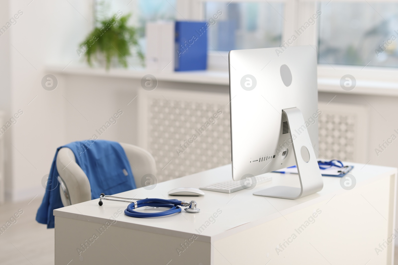 Doctor's workplace with stethoscope, paperwork and computer on desk. Space for text Photo of Doctor's workplace with stethoscope, paperwork and computer on desk. Space for text