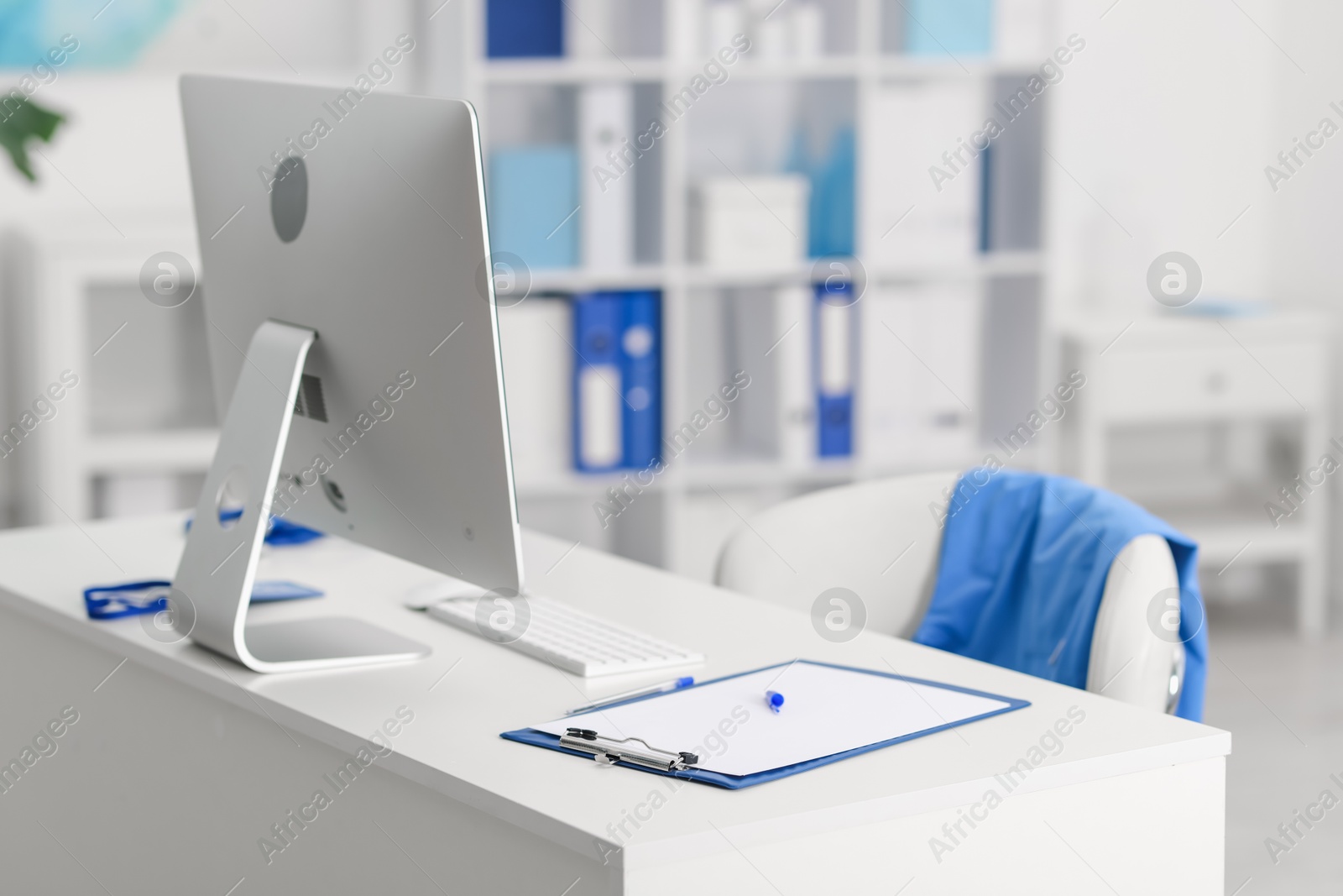 Doctor's workplace with computer and paperwork on desk. Space for text Photo of Doctor's workplace with computer and paperwork on desk. Space for text