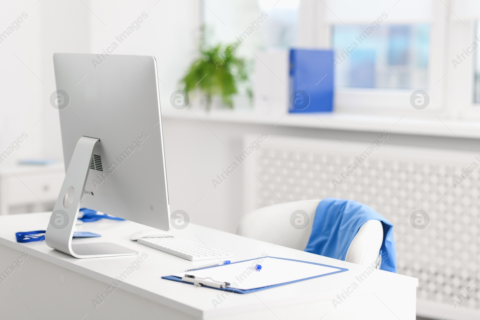 Doctor's workplace with computer and paperwork on desk. Space for text Photo of Doctor's workplace with computer and paperwork on desk. Space for text