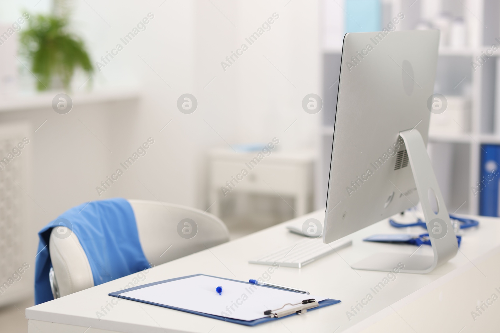 Doctor's workplace with computer and paperwork on desk. Space for text Photo of Doctor's workplace with computer and paperwork on desk. Space for text