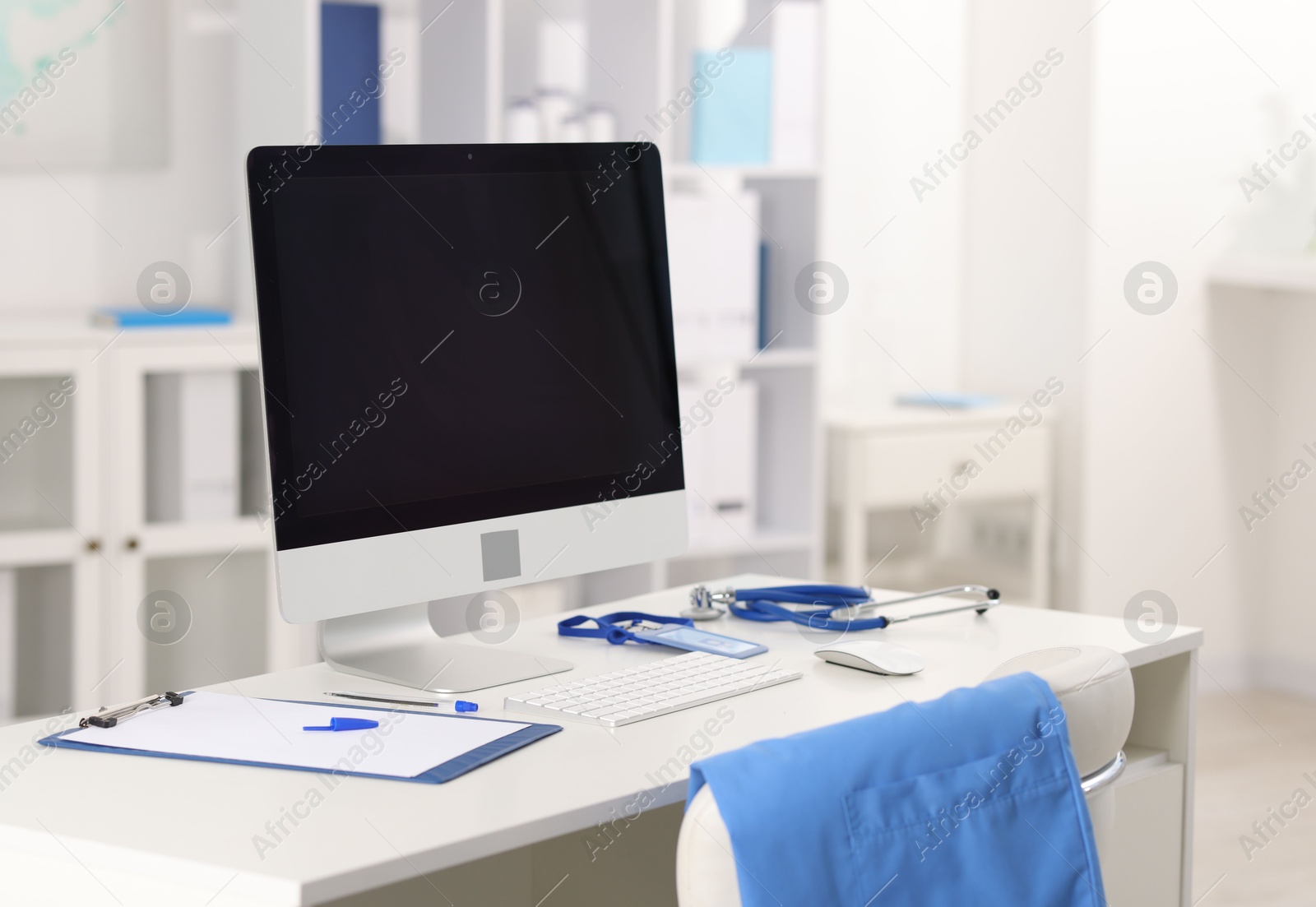 Doctor's workplace with stethoscope, paperwork and computer on desk Photo of Doctor's workplace with stethoscope, paperwork and computer on desk