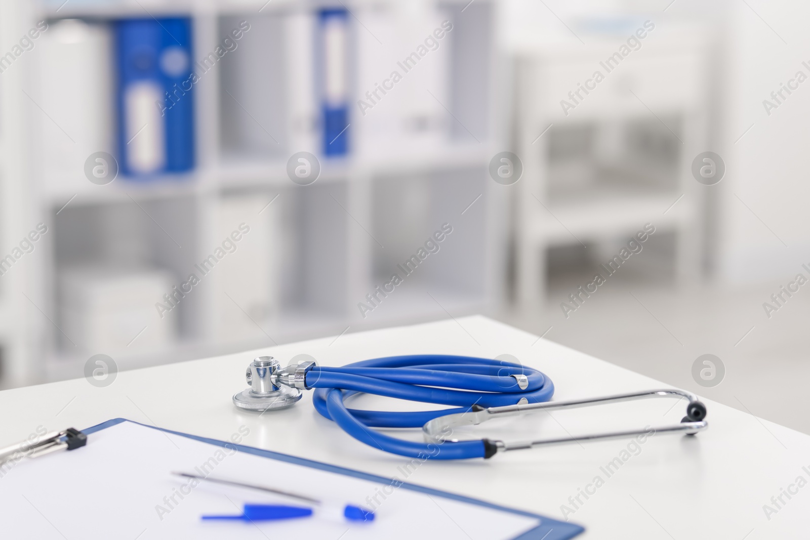 Doctor's workplace with stethoscope and paperwork on desk, closeup. Space for text Photo of Doctor's workplace with stethoscope and paperwork on desk, closeup. Space for text
