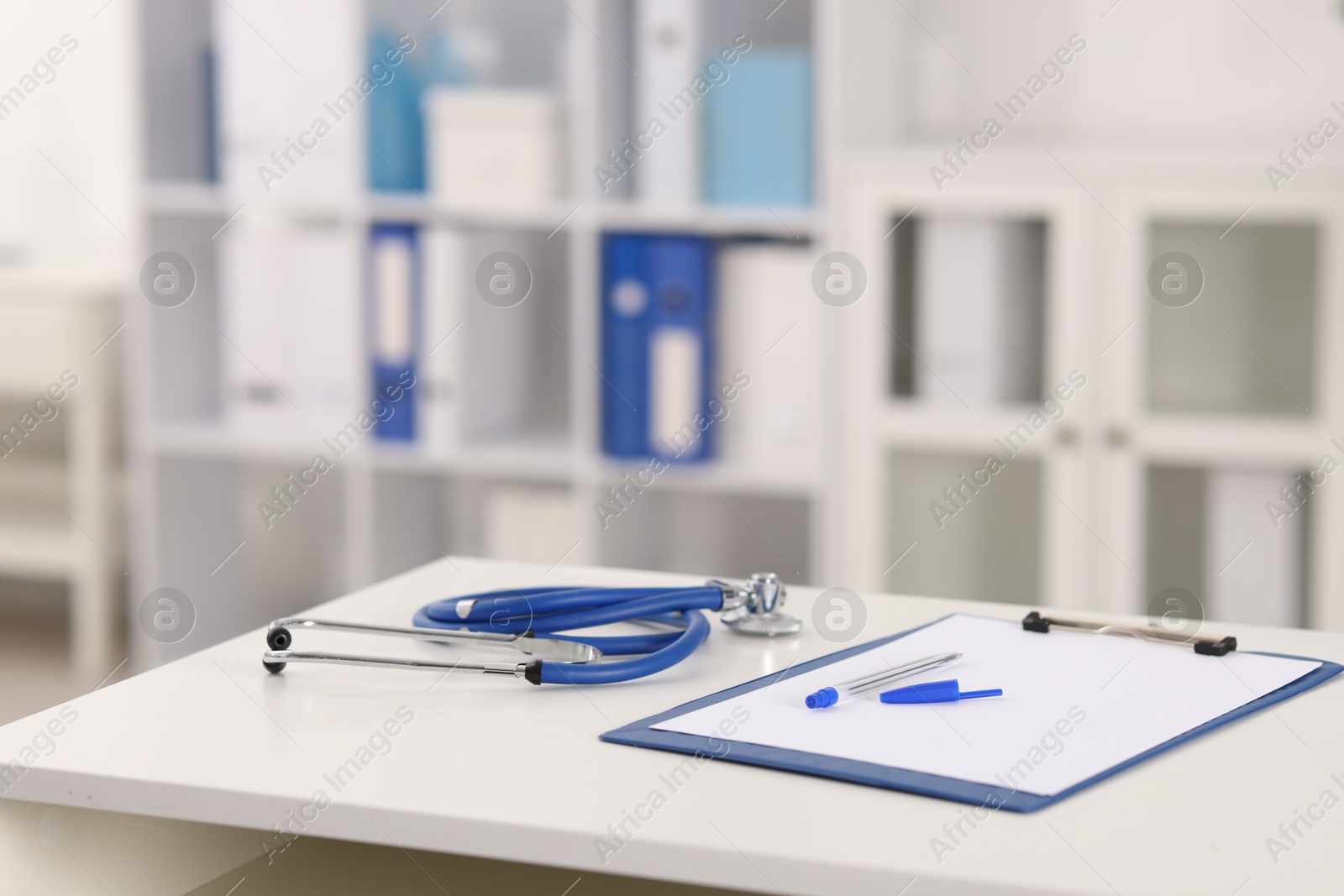 Doctor's workplace with stethoscope and paperwork on desk, closeup. Space for text Photo of Doctor's workplace with stethoscope and paperwork on desk, closeup. Space for text